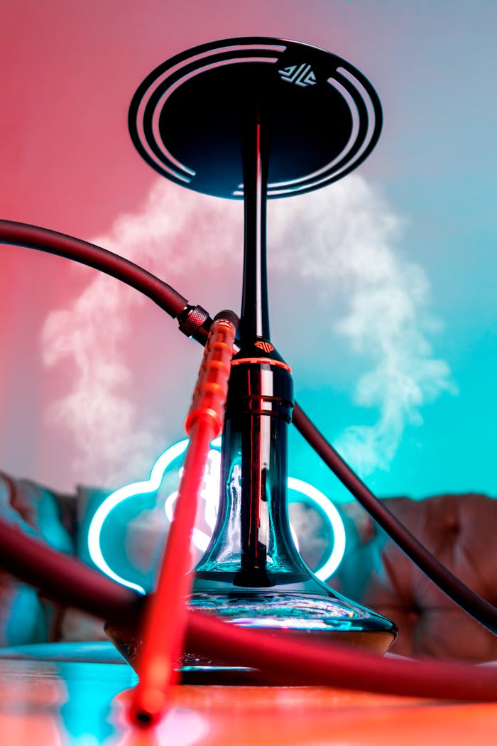 Colorful still life of a hookah with neon lights and smoke.